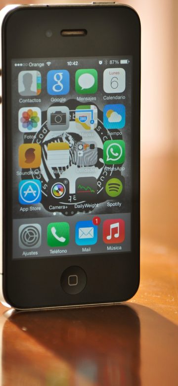 手机竖屏显示免费在线视频 App 首页推荐列表，深色背景上排列着封面缩略图与最近观看进度条，夜间室内光线柔和